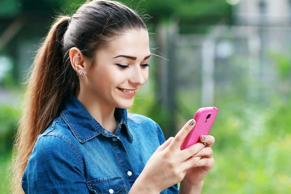 Молодая девушка использует мобильный телефон — стоковое фото
