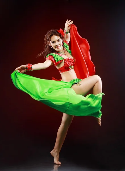 Woman dancing in green and red costume — Stock Photo, Image