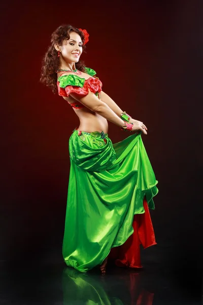Woman dancing in green and red costume