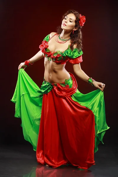 Frau tanzt in grün-rotem Kostüm — Stockfoto