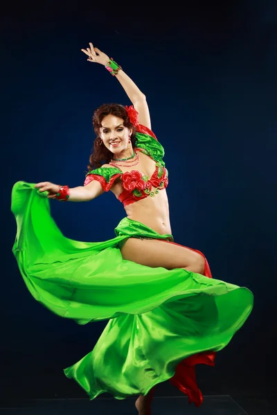 Woman dancing in green and red costume — Stock Photo, Image