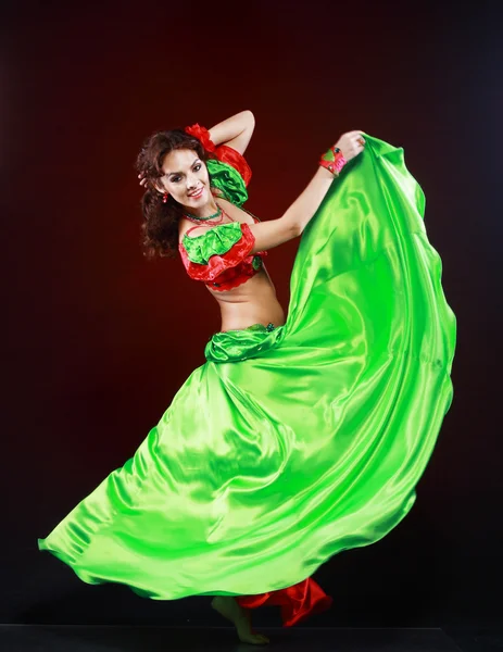 Woman dancing in green and red costume — Stock Photo, Image