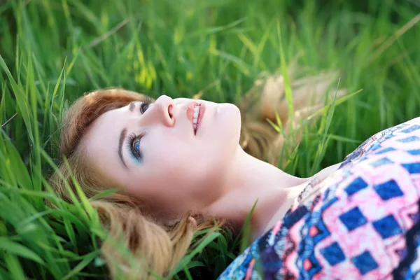 Жінка лежить на зеленій траві — стокове фото