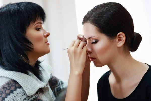 Mujer aplicando maquillaje por maquillador —  Fotos de Stock