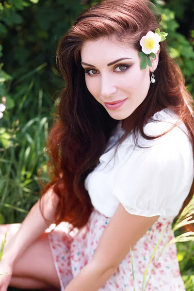 Beautiful brunette woman with flowers — Stock Photo, Image