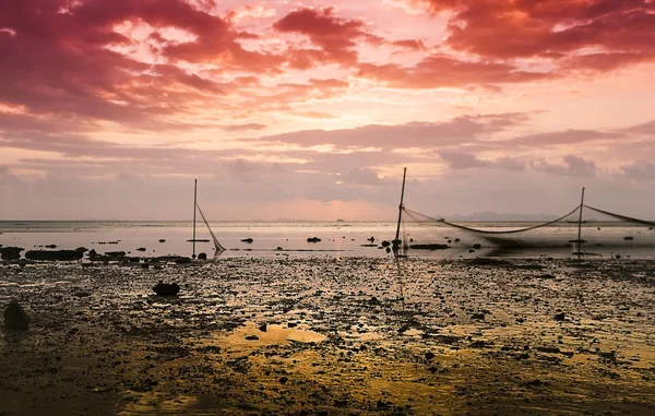 Rede de pesca é refletida na água ao pôr do sol — Fotografia de Stock