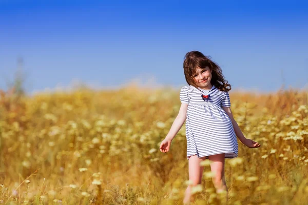 Kleines Mädchen in einem schwarz-weiß gestreiften Kleid — Stockfoto