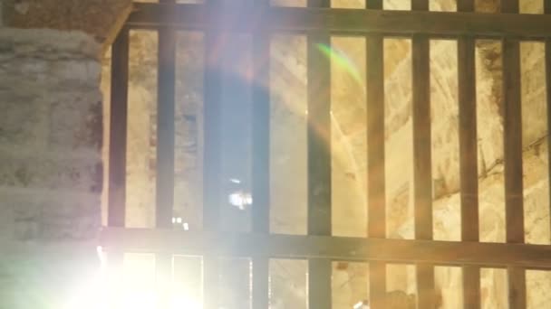 Blask promieni słonecznych przez bary starożytnej bramy twierdzy — Wideo stockowe