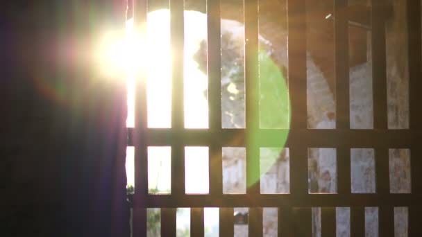 Záři slunečního záření přes pruhy starých bran pevnosti — Stock video