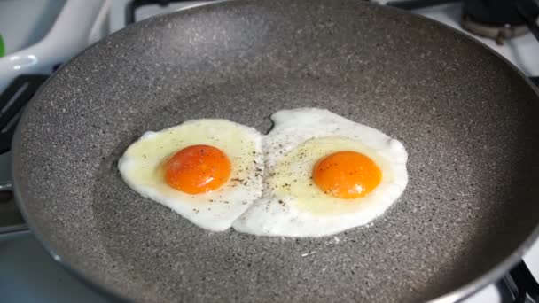 Дві смажені яєчні жовтки смажені на кам'яній сковороді — стокове відео