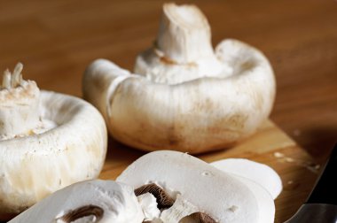 Ahşap tahta üzerinde tüm ve dilimlenmiş beyaz mantar