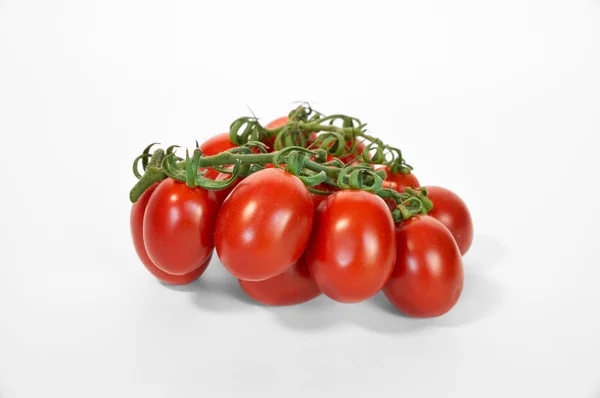 Pomodori maturi rossi sulla linea verde da vicino bianco — Foto Stock