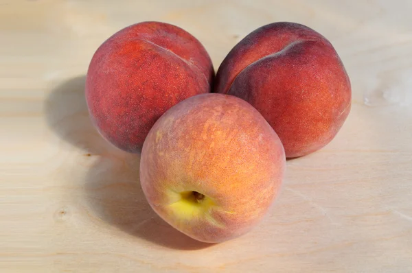 Juicy ripe peach with Golden sideways on wooden — Stock Fotó