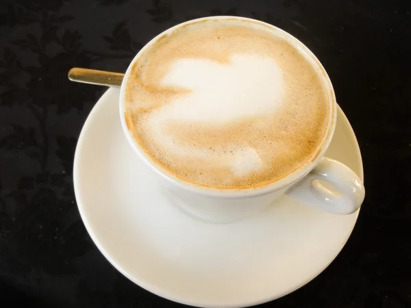 Weiße Tasse mit Gourmet-Kaffee und Schaumfigur — Stockfoto
