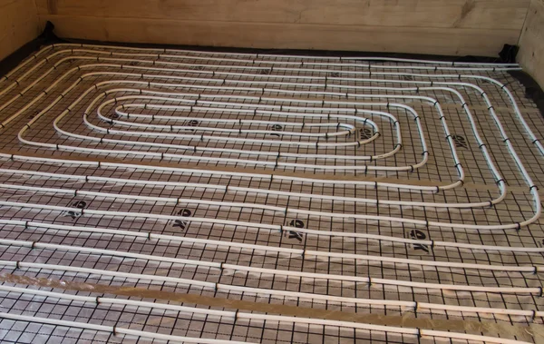 Underfloor heating pipes spread on polystyrene covered with foil — Stock Photo, Image