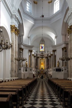 Chelm, Polonya, 25 Eylül 2020: Kilise içi, Polonya 'nın doğusundaki Chelm' de Meryem Ana 'nın mabedi, ana sunağın önünde diz çöküp çiçekleri düzenleyen bir rahibe.