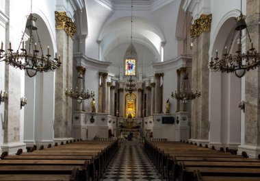 Chelm, Polonya, 25 Eylül 2020: Kilise içi, Polonya 'nın doğusundaki Chelm' de Meryem Ana 'nın mabedi, ana sunağın önünde diz çöküp çiçekleri düzenleyen bir rahibe.