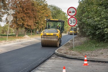 Yol silindiri asfaltın üst katmanını düzleştiriyor
