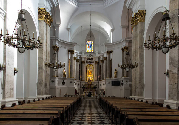 Челм, Польша, 25 сентября 2020 г.: Интерьер церкви, святилище Пресвятой Богородицы в Челме на востоке Польши с монахиней, стоящей на коленях и расставляющей цветы перед главным алтарем