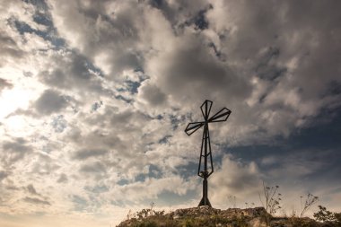 Polonya 'nın Czestochowa yakınlarındaki Olsztyn yakınlarındaki Biaklo (veya Maly Giewont) tepesindeki açık gökyüzünün arka planındaki haç