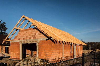 Küçük, basit bir konut inşaatı. Çatı kirişli ham durum.