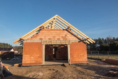 Küçük, basit bir konut inşaatı. Çatı kirişli ham durum.