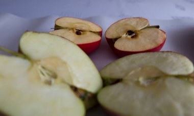 İki dilimlenmiş elmanın yarısı. Bir elmanın tanecikleri var ve diğerinde tahıl olmasın diye modifiye edilmiş..