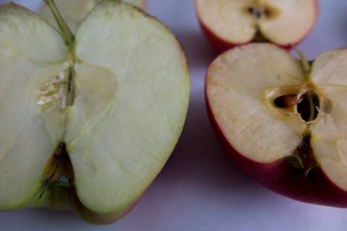 İki dilimlenmiş elmanın yarısı. Bir elmanın tanecikleri var ve diğerinde tahıl olmasın diye modifiye edilmiş..