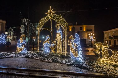 Chelm, Polonya, 9 Ocak 2021: Noel 'den sonraki kış akşamları şehir sokaklarına karakteristik tatil süslemeleriyle bakmak.