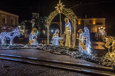 Chelm, Polonya, 9 Ocak 2021: Noel 'den sonraki kış akşamları şehir sokaklarına karakteristik tatil süslemeleriyle bakmak.