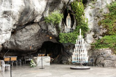 Statue of Our Lady of Immaculate Conception with a rosary in the Grotto of Massabielle in Lourdes, France clipart