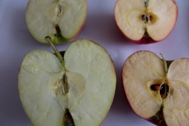 İki dilimlenmiş elmanın yarısı. Bir elmanın tanecikleri var ve diğerinde tahıl olmasın diye modifiye edilmiş..