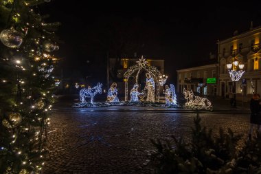 Chelm, Polonya, 9 Ocak 2021: Noel 'den sonraki kış akşamları şehir sokaklarına karakteristik tatil süslemeleriyle bakmak.