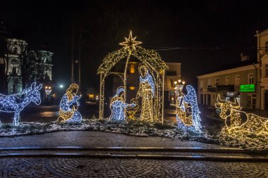Chelm, Polonya, 9 Ocak 2021: Noel 'den sonraki kış akşamları şehir sokaklarına karakteristik tatil süslemeleriyle bakmak.