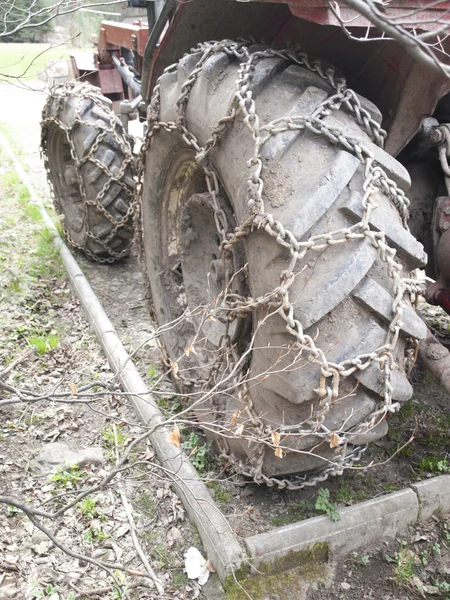 Kerekes traktor dolgozik a hegyekben, a lánc, a gumiabroncs — Stock Fotó