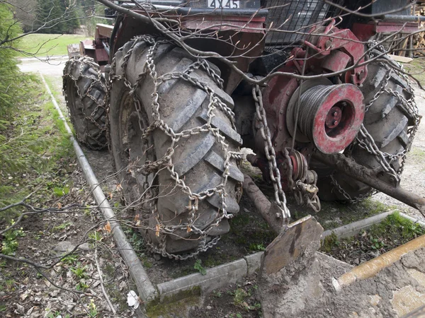 Tractor de ruedas trabajando en las montañas de la cadena en el neumático —  Fotos de Stock