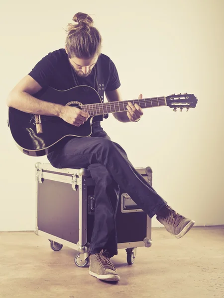 Young man sitting and playing guitar — Stock Photo, Image