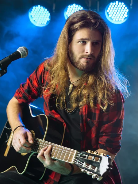 Homem tocando guitarra acústica em concerto — Fotografia de Stock