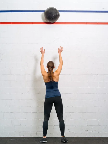 Жінка кидає медичний м'яч у спортзал — стокове фото