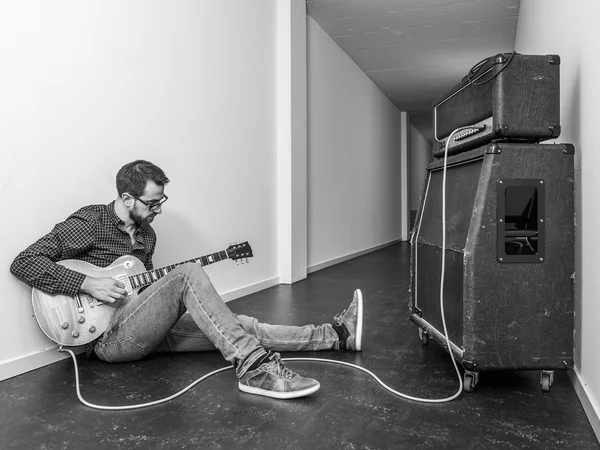 Hraje elektrickou kytaru v dlouhé chodbě — Stock fotografie