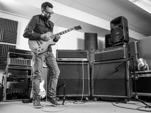 Practicing his electric guitar in a jam room — Stock Photo, Image