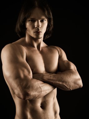 Muscular young man with arms crossed