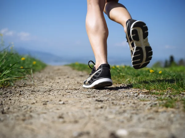 Jambes d'une femme joggeuse dans le pays — Photo