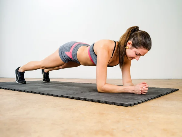 Mujer joven haciendo tablón de codo — Foto de Stock