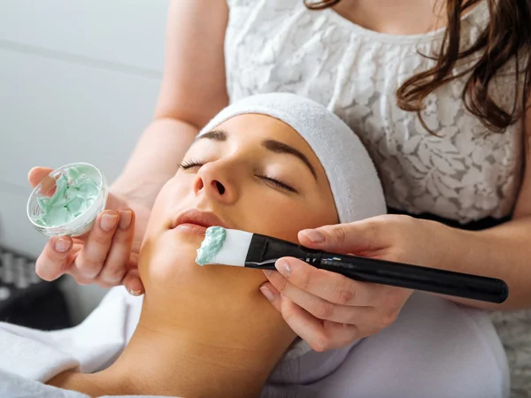 Jonge vrouw met een gezichtsbehandeling in de salon — Stockfoto