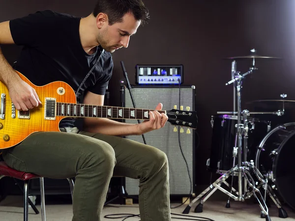 Guitarist sitting and playing on stage — Stock Photo, Image