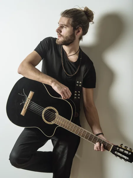 Bonito jovem segurando guitarra acústica — Fotografia de Stock