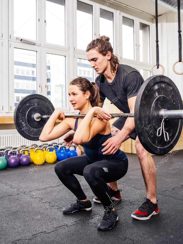 Woman doing squats at crossfit gym