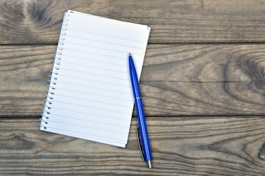 Ahşap masa üstünde beyaz defter