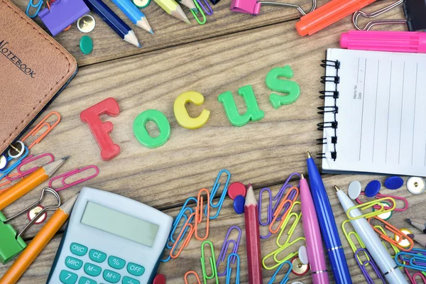 Focus word and office tools on wooden table — Stock Photo, Image